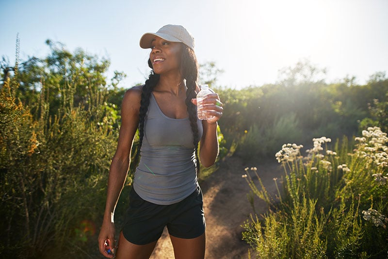 woman hiking and drinking water