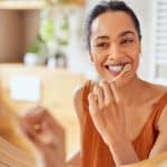 woman brushing her teeth using at home dental care tips from the dentist in louisville